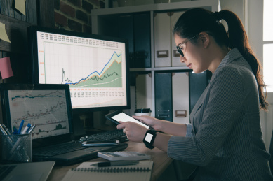 甜美清秀的女人看空平板电脑在办公室。混血亚洲中国模式保持垫座，专注于屏幕。