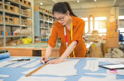 美女设计师的职业和职务侵占的概念。女士草图绘制新的服装纸样设计时装工作室用粉笔和标尺。