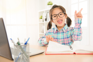 教育和行动学习理念。小的学生在学习的眼镜，并在计算机和手指快乐的学校读的书。