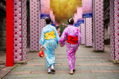 日本和服的年轻女孩加入日本当地节日一起行走于传统服饰打扮晴天日本当地历史文化的途径暑假。