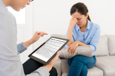 专业的年轻医生使用移动平板电脑开放精神状态检查文档记录病人的心理问题。