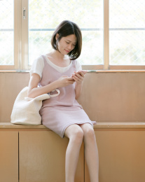 女生坐在窗边用手机