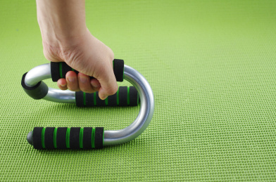 撑起绿色瑜伽垫上的俯卧撑支架