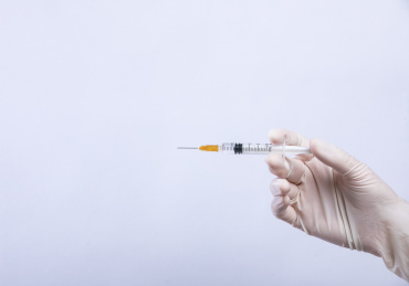 白色背景手持注射器特写