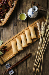 金黄色的春卷、麦穗和青花瓷小酒壶