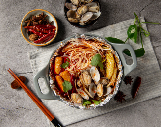 灰色背景的木制砧板上的锡纸花甲汤面