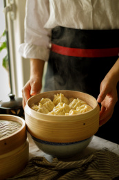 厨师端起刚出锅 冒热气的小笼包