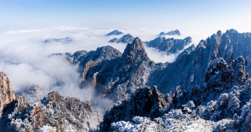 中国安徽黄山风景区，冬日雪后奇峰怪石林立、云雾飘渺，宛若仙境