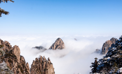 中国安徽黄山风景区，冬日雪后奇峰怪石林立、云雾飘渺宛若仙境
