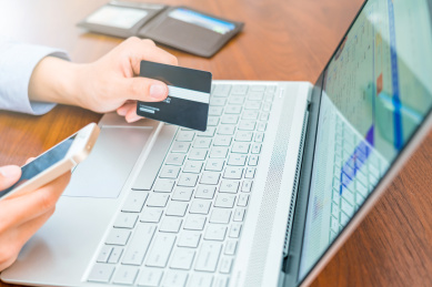 手拿信用卡网上购物的消费者