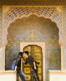 年轻情侣在印度斋浦尔城市宫殿中的玫瑰门的门前