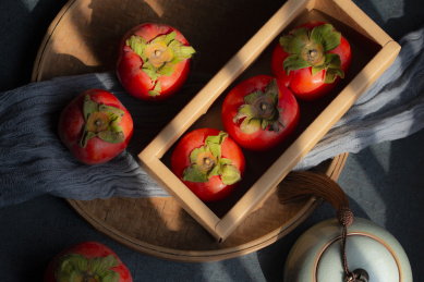 黑背景下摆放有序的精致的柿子礼盒