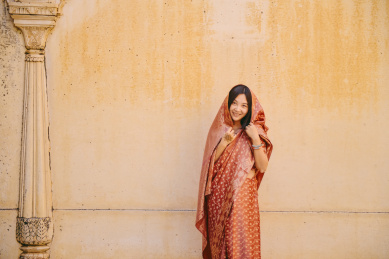 中国女性身穿传统印度纱丽站在古老的城墙下