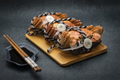 黑背景下精致摆放的三只煮熟的阳澄湖大闸蟹