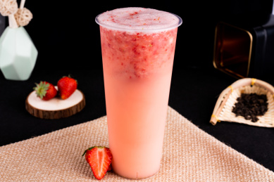 黑色背景下的鲜榨冰冻茶饮料，鲜榨草莓奶茶