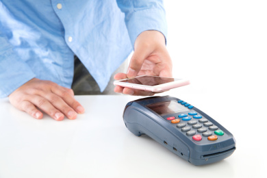 白背景上手拿手机在pos机上扫描付款