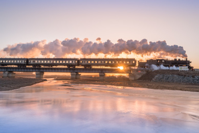 冬季中国辽宁省铁岭市冰河上的铁路桥和蒸汽机车