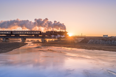 冬季中国辽宁省铁岭市冰河上的铁路桥和蒸汽机车
