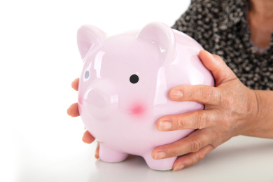 黄皮肤老太太手捧小猪存钱罐