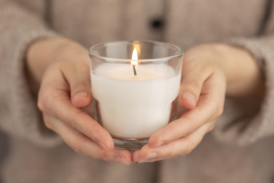 双手捧着正在燃烧的蜡烛灯