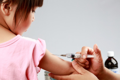 医生为小女孩在胳膊上打预防针