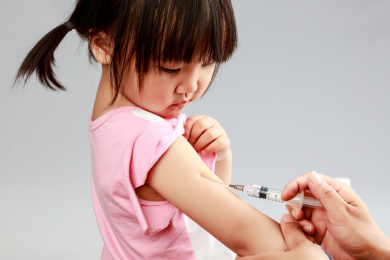 医生为小女孩在胳膊上打预防针