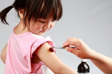 小女孩胳膊上打针时做消毒处理