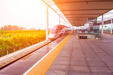  阳光下正在出站的高铁列车特写