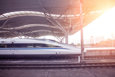  阳光下正在出站的高铁列车特写