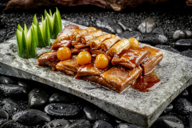 葱烧羊排摆放在黑色鹅卵石上