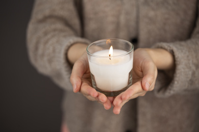 双手捧着正在燃烧的蜡烛灯祈祷祝福