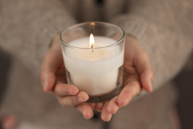 女人双手捧着蜡烛灯祈祷着