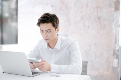 坐在笔记本电脑前工作的年轻中国男性