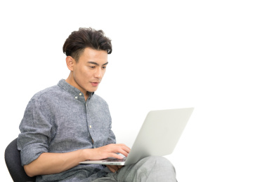 白背景前年轻商务男士正使用笔记本电脑工作