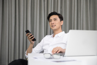 男性工作者正坐在办公室里电脑前想事情