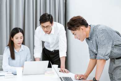 三个着职业装在办公室工作的年轻职员