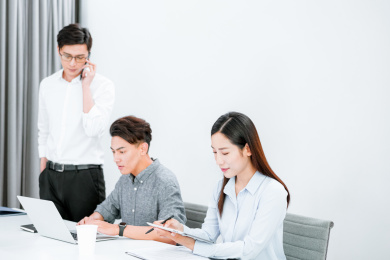 三个着职业装在办公室工作的年轻职员