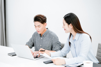 两个着职业装在办公室工作的年轻职员