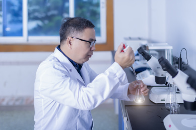 一名东方男性研究人员在实验室里进行操作