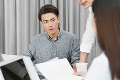 一名男职员认真倾听其他同事的想法
