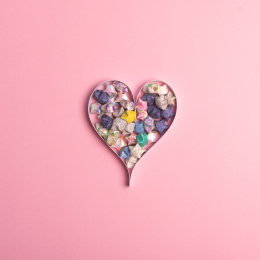 浅色背景上纸条折叠成的心形裹着星星