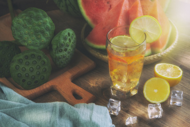 木质桌子上放着莲蓬西瓜柠檬冰块