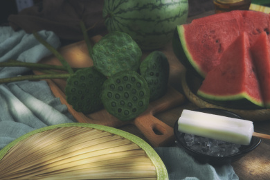 木质桌子上放着莲蓬西瓜柠檬冰块