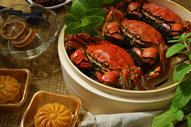 俯视餐桌上的中秋中国传统美食大闸蟹和月饼