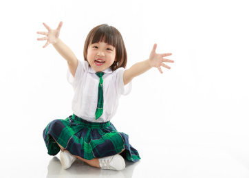 穿校服的小女孩在白色背景前坐在地上做伸手姿势