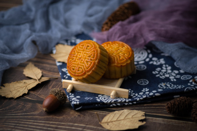 月饼搭配青花瓷中国风蓝布放在木纹质感的桌子上