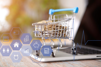 笔记本电脑键盘上满载欧元硬币的购物车