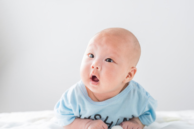 白色背景前趴着的初生婴儿