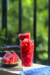一杯西瓜汁与切片的西瓜摆放在阳台的木板上