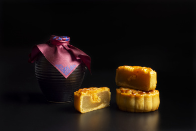 黑色背景中放着的月饼和酒壶